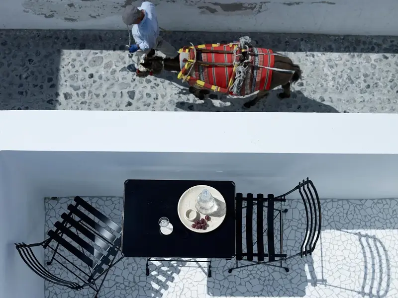 Une table noire est mise en scène avec de la vaisselle sur une terrasse carrelée.