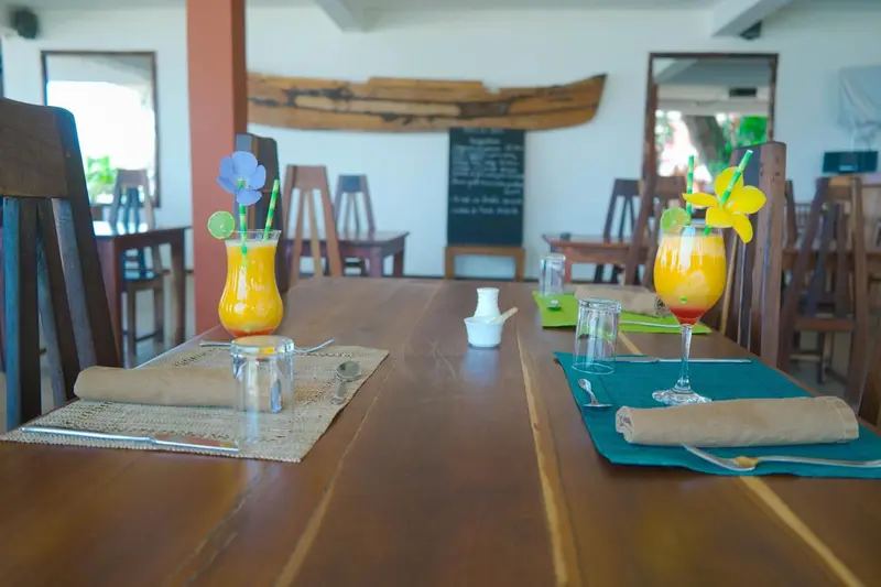 Une table est dressée avec des boissons colorées et de la vaisselle.
