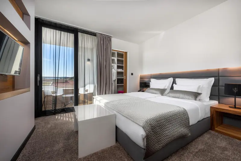 Une chambre moderne avec un grand lit et un accès à une terrasse.