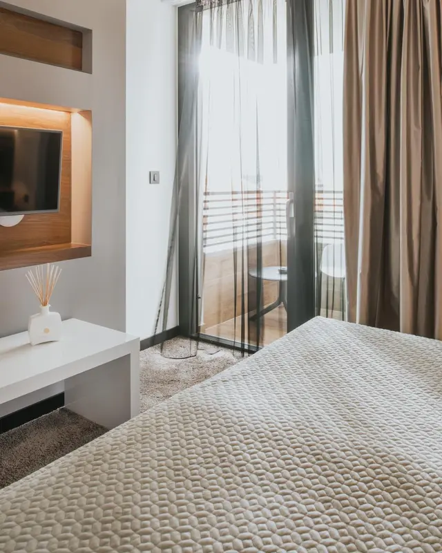 Une chambre lumineuse avec un grand lit et un accès à une terrasse.