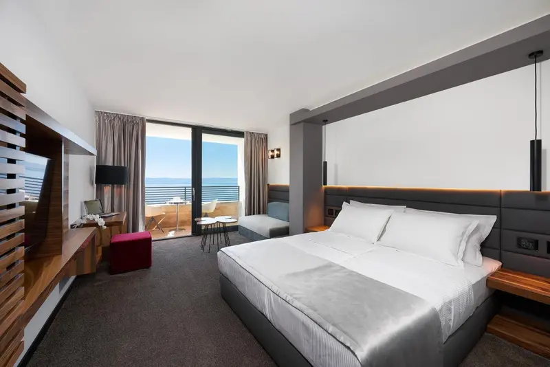 Chambre moderne avec un grand lit et une vue sur la mer.