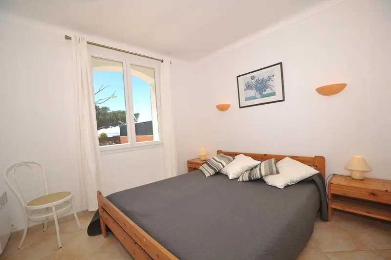 Une chambre lumineuse avec un lit et une fenêtre.