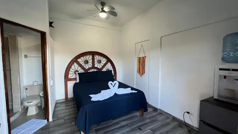 Une chambre avec un grand lit décoré de serviettes en forme de cygnes.