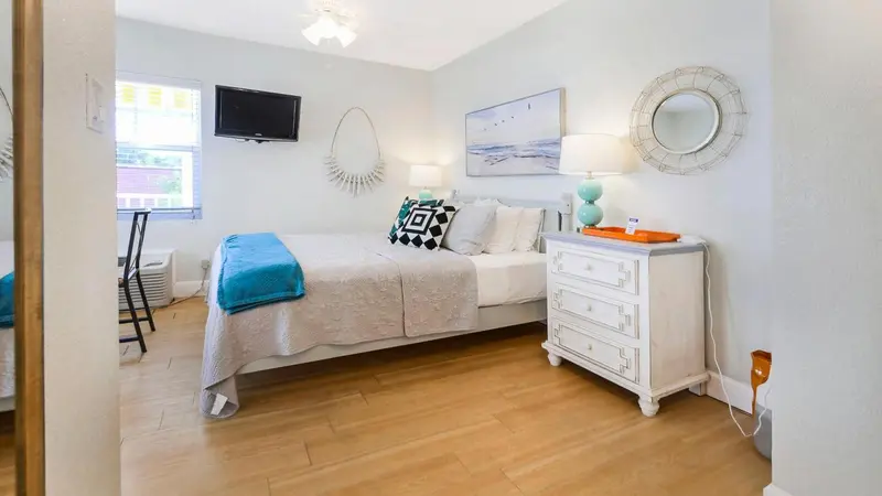 Une chambre lumineuse avec un lit fait et une décoration sobre.