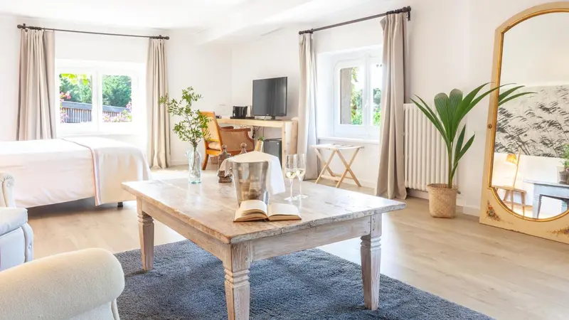 Une chambre lumineuse avec un bureau et une table basse décorée.