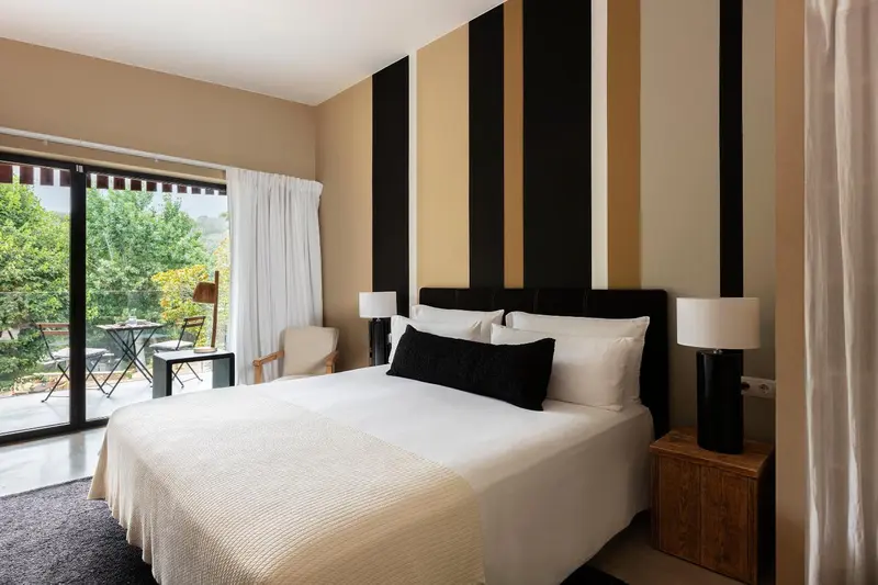 Une chambre lumineuse avec un grand lit et un accès à une terrasse.