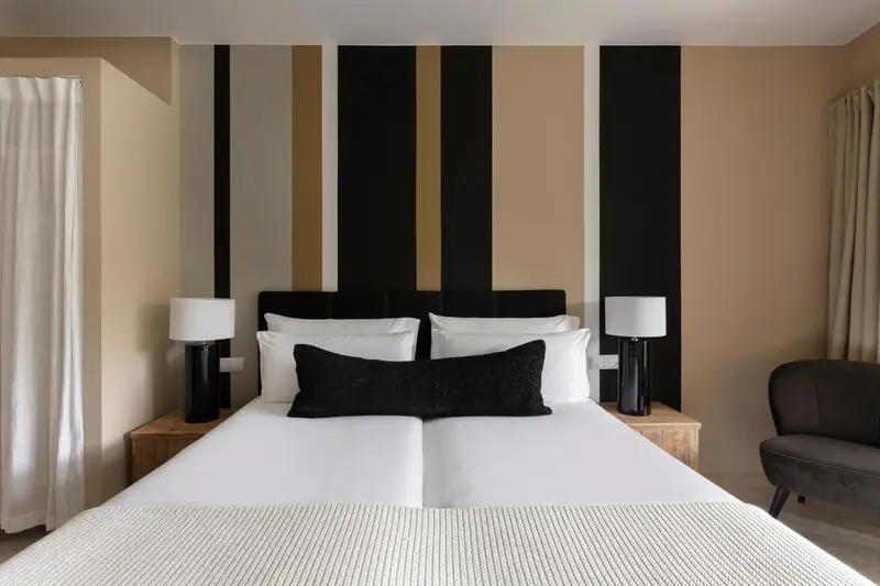 Un lit blanc est dispose dans une chambre avec un mur decoratif.