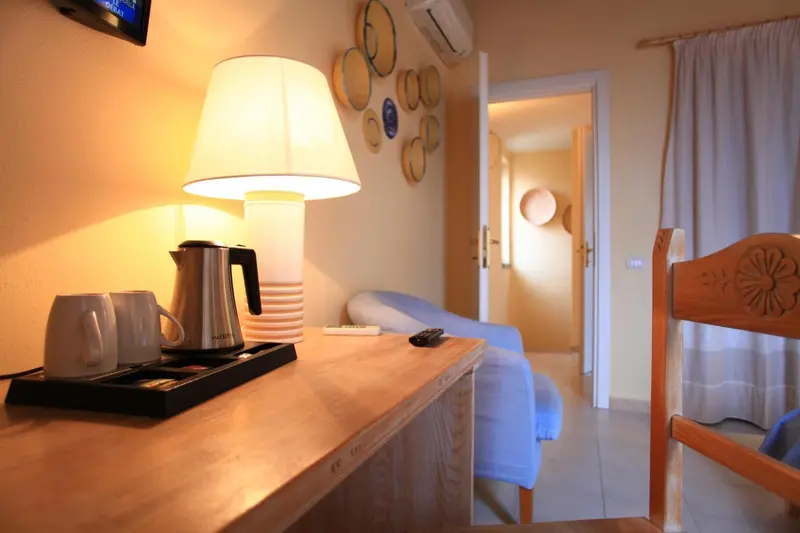 Une table de chevet avec une lampe et un plateau de boissons dans une chambre.