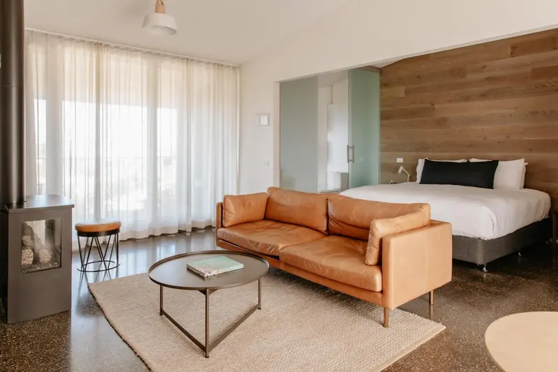 Espace de vie intérieur avec canapé en cuir et lit confortable.
