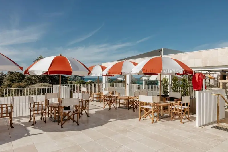 Terrasse aménagée avec parasols rayés et mobilier de jardin.