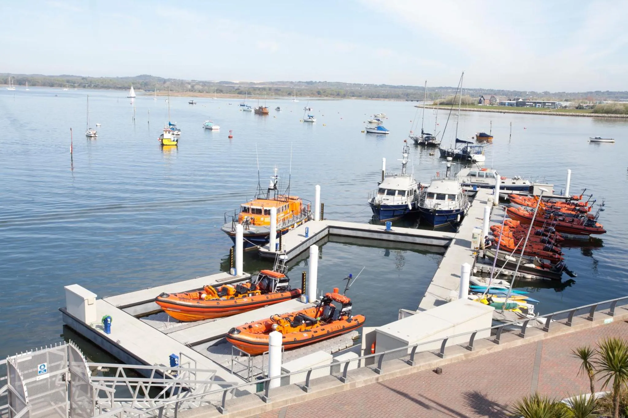 Plusieurs bateaux sont amarrés à un ponton en bord de mer.