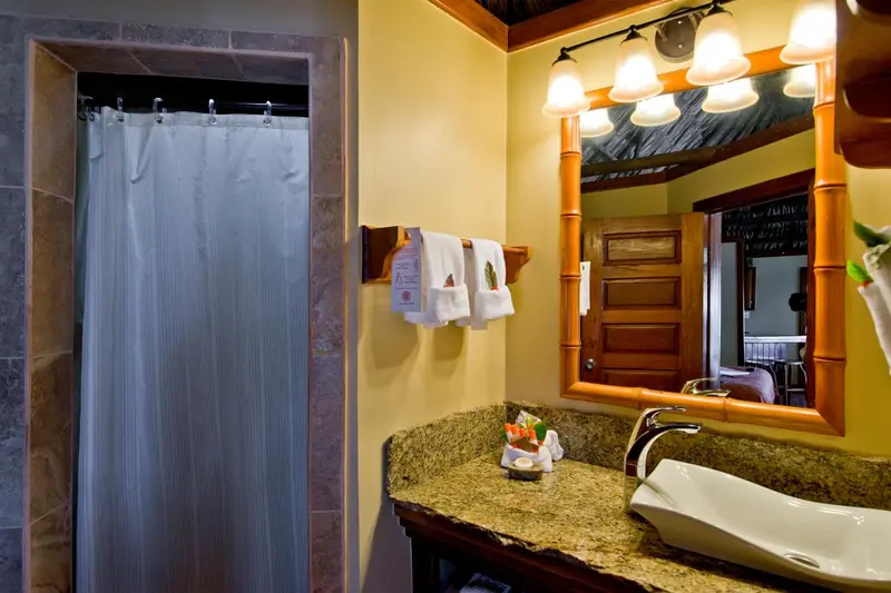 Une salle de bain lumineuse avec douche et vasque.