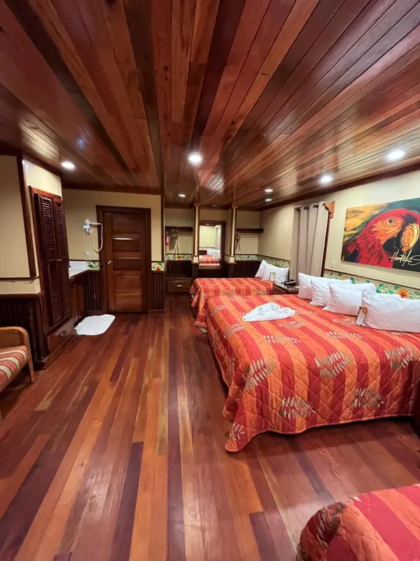 Chambre avec lits jumeaux et décoration tropicale.