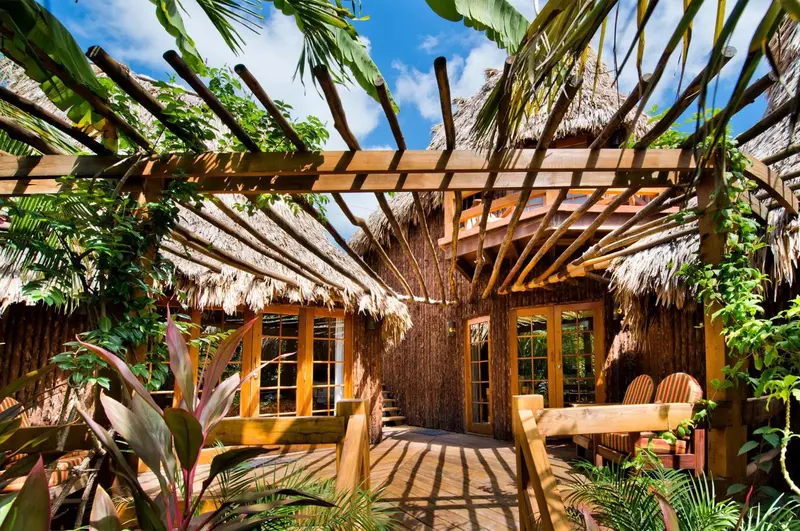 Terrasse ombragée en bois avec mobilier de jardin.