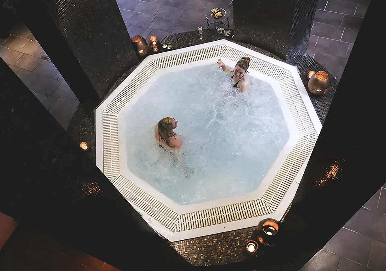 Deux personnes se détendent dans un jacuzzi intérieur.