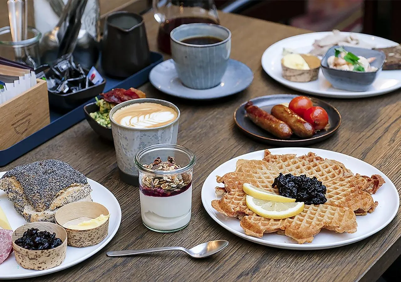 Table garnie de divers plats et boissons pour le petit-déjeuner.