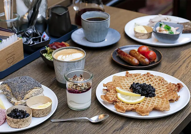 Table garnie de divers plats et boissons pour le petit-déjeuner.