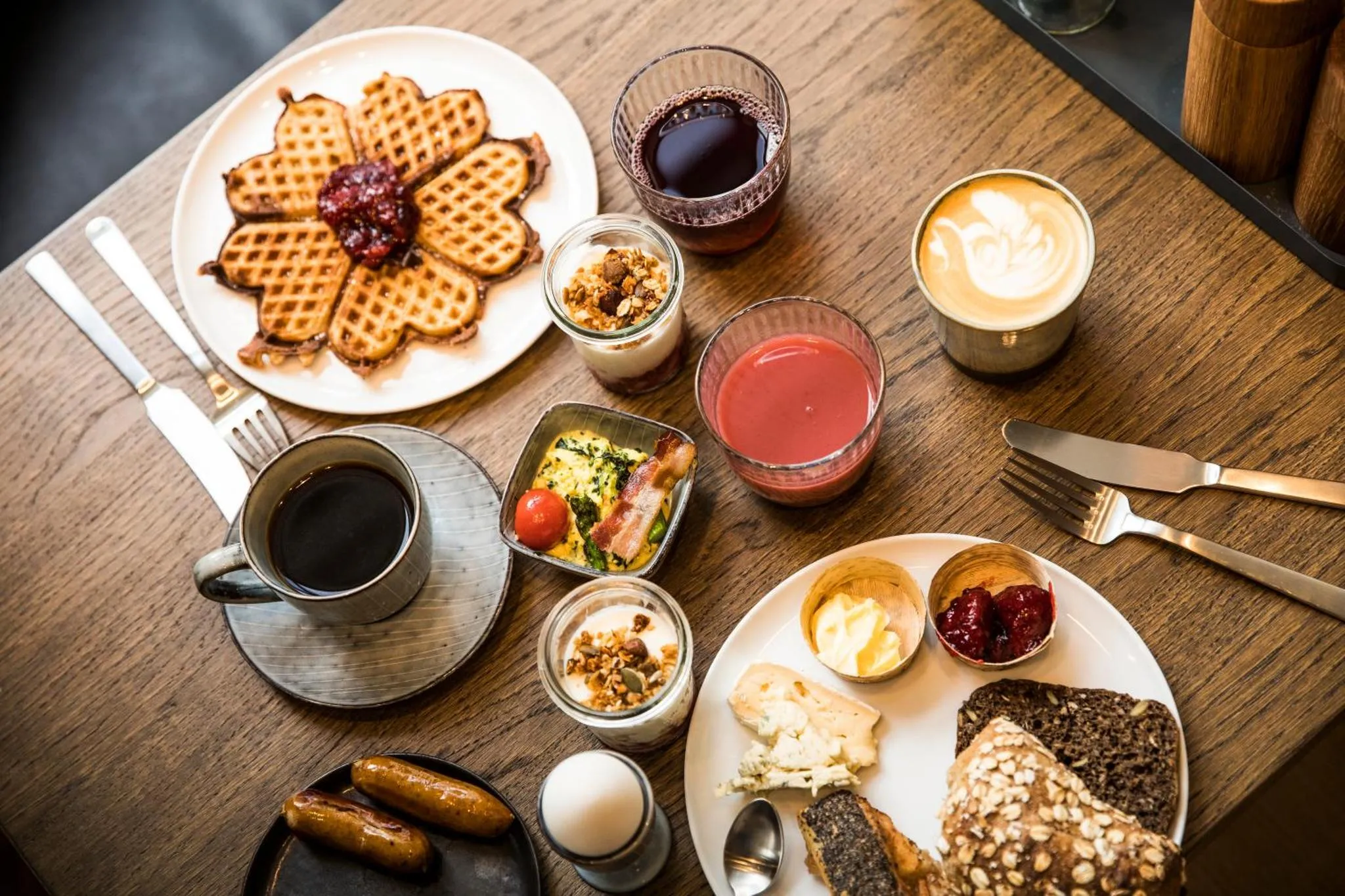 Un petit-déjeuner copieux est présenté sur une table en bois.