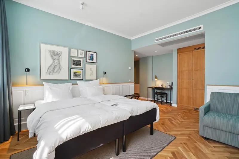 Une chambre lumineuse avec un grand lit et un coin salon.
