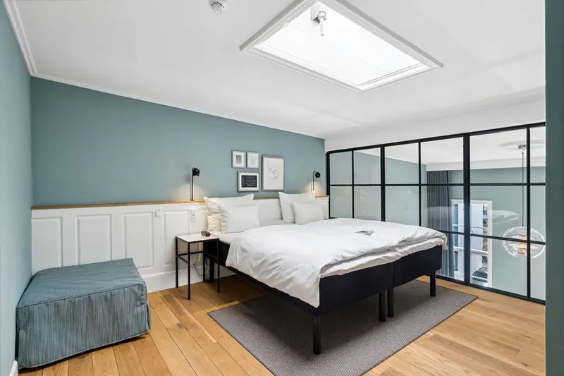 Une chambre lumineuse avec un lit double et un espace détente.