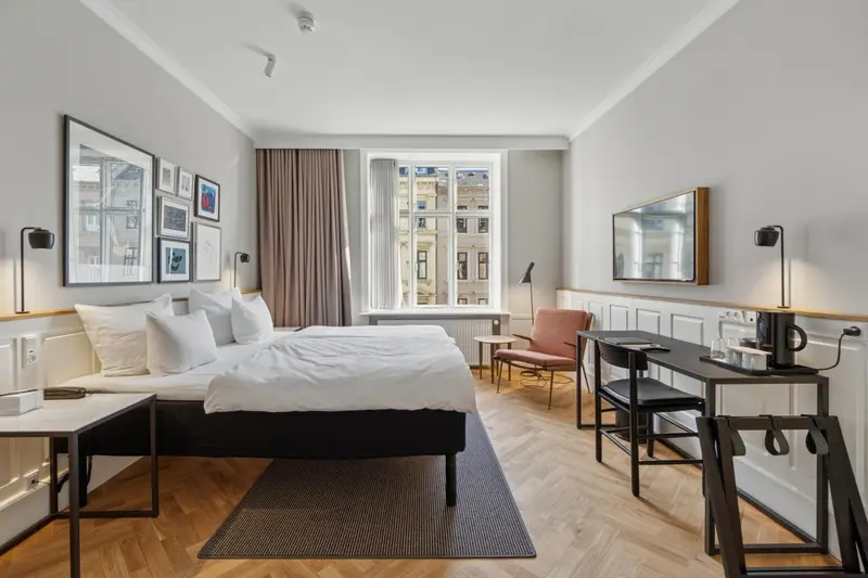 Une chambre lumineuse avec un grand lit et un bureau.