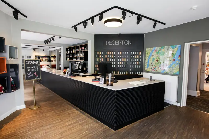 Un comptoir d'accueil moderne avec un mur gris et un sol en bois.
