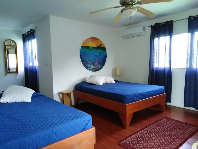 Une chambre lumineuse avec deux lits simples et une décoration marine.