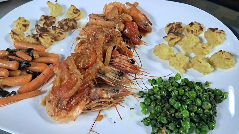Assiette de crevettes grillées accompagnées de légumes et de pommes de terre.