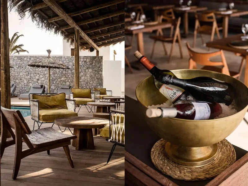 Une bouteille de vin dans un seau à glace sur une terrasse ombragée avec des fauteuils et une piscine en arrière-plan.