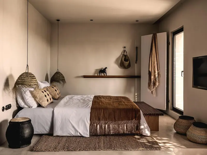 Une chambre à coucher minimaliste avec un lit recouvert de textiles naturels.