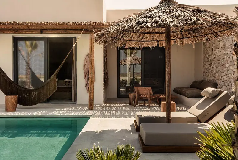 Espace de détente extérieur avec piscine et mobilier de jardin.