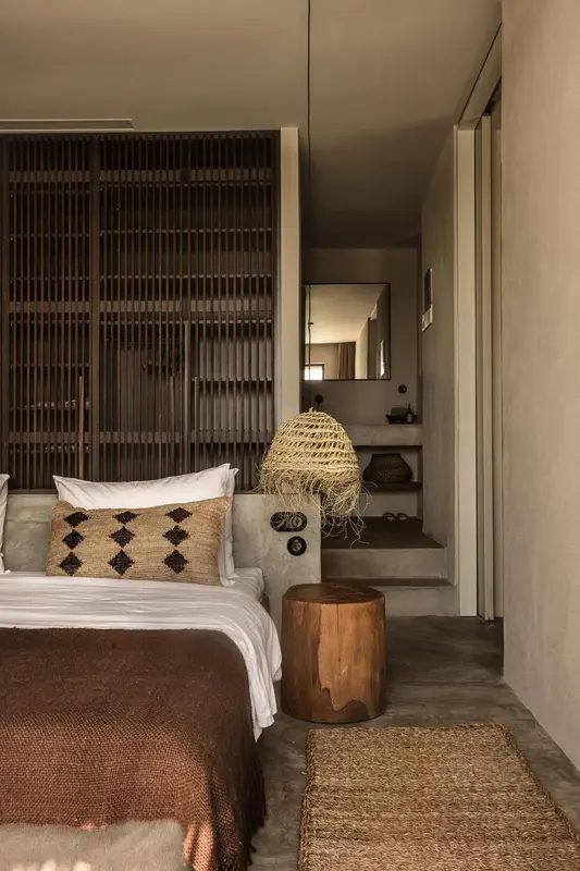 Une chambre à coucher avec un lit recouvert d'une couverture et d'oreillers décoratifs.