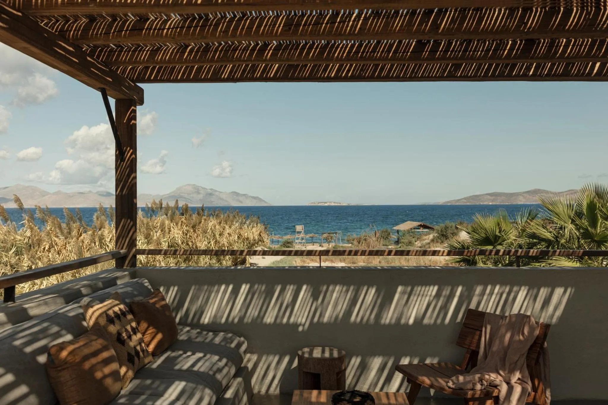 Terrasse ombragée donnant sur une vue mer et montagne.
