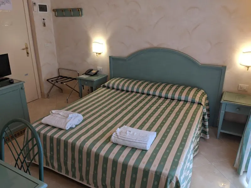 Une chambre lumineuse avec un lit recouvert d'une couette à motifs.