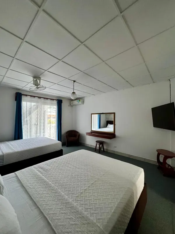 Une chambre lumineuse avec deux lits et un miroir.