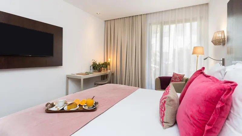 Une chambre d'hôtel avec un lit préparé pour le petit-déjeuner.