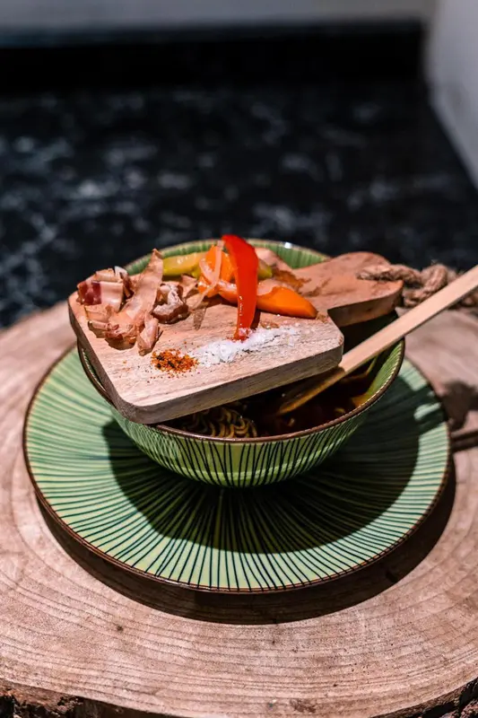 Assiette de nourriture avec des légumes et de la viande présentés de manière artistique.