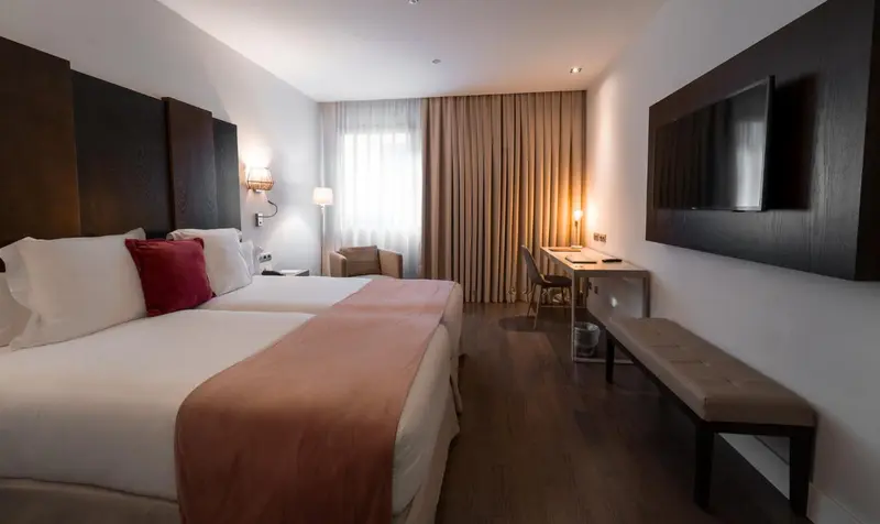 Une chambre d'hôtel moderne avec un grand lit et un bureau.