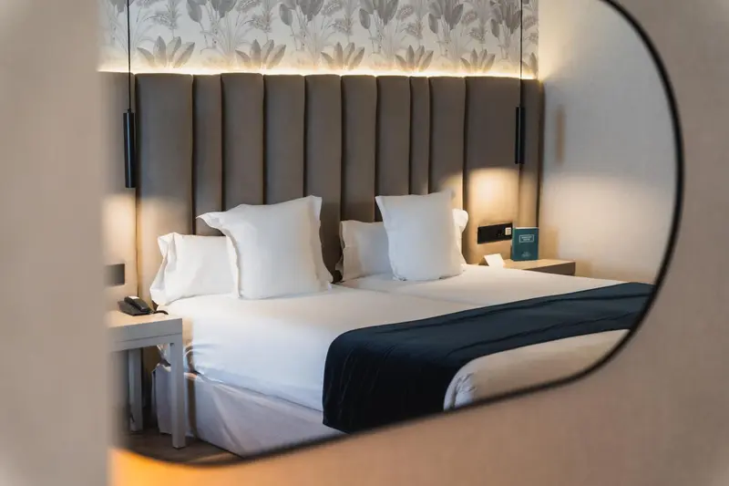 Un lit double avec des oreillers blancs dans une chambre moderne.