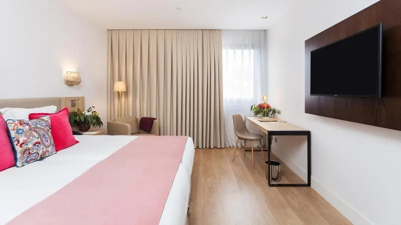 Une chambre lumineuse avec un grand lit et un espace de travail.