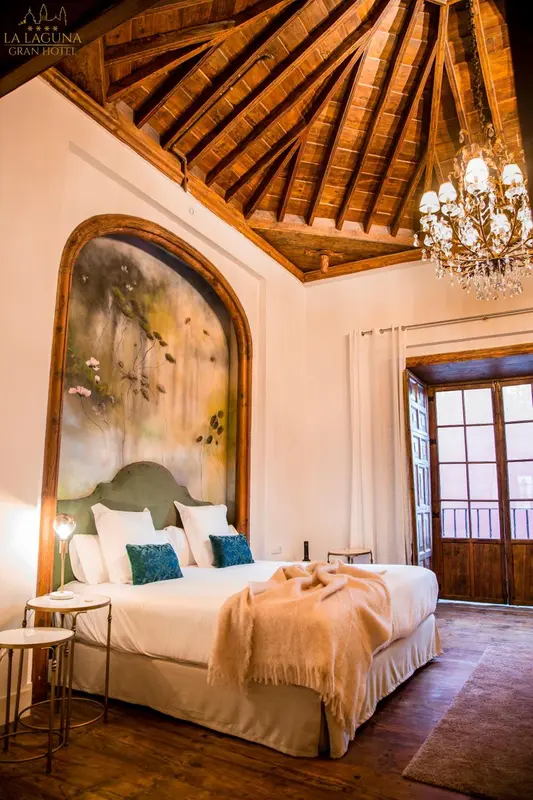 Une chambre à coucher lumineuse avec un grand lit et une décoration murale florale.
