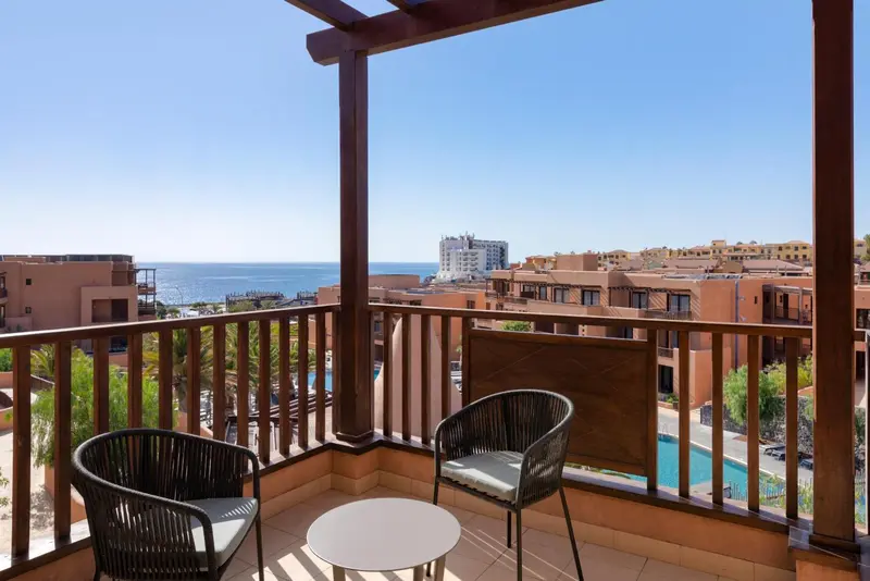 Terrasse avec mobilier d'extérieur donnant sur une vue côtière.