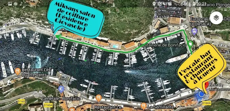 Vue aérienne d'un port de plaisance avec des bateaux amarrés et des bâtiments colorés.