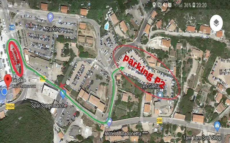 Vue aérienne d'un parking et d'une zone côtière avec des bâtiments.