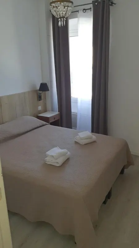 Une chambre avec un lit recouvert d'une courtepointe et des serviettes pliées.