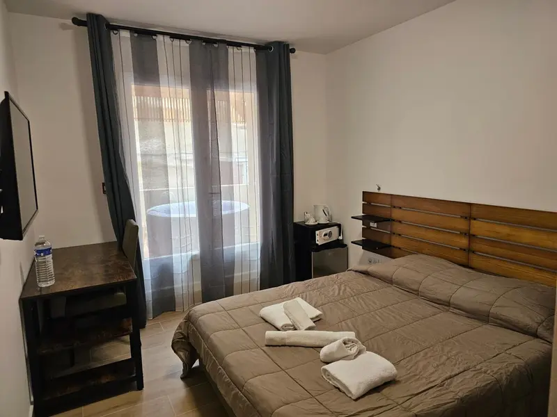 Une chambre avec un lit et un bureau près d'une fenêtre.