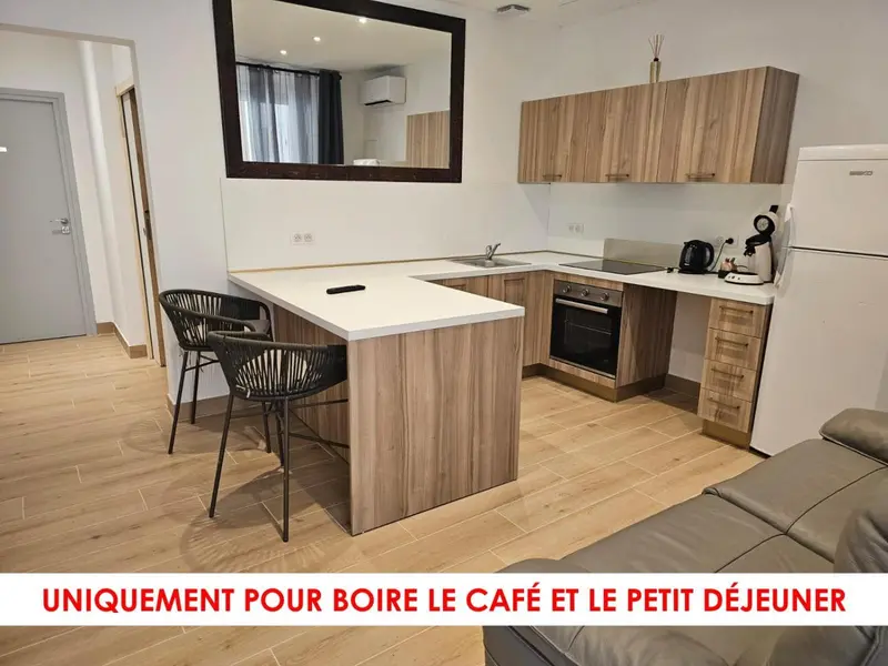 Une cuisine moderne avec un îlot central et des tabourets.