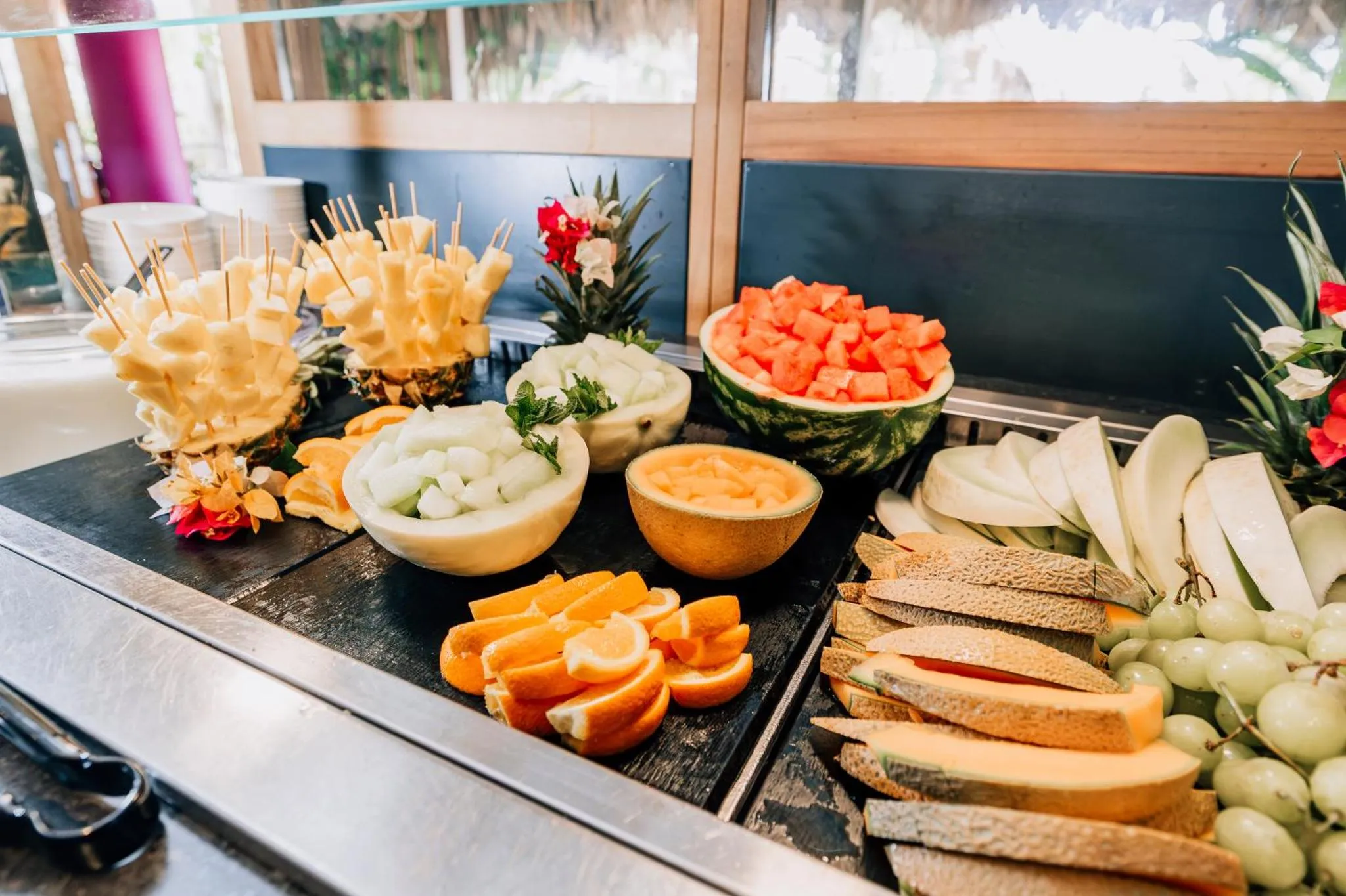 Présentation colorée de fruits frais coupés et disposés sur un buffet.