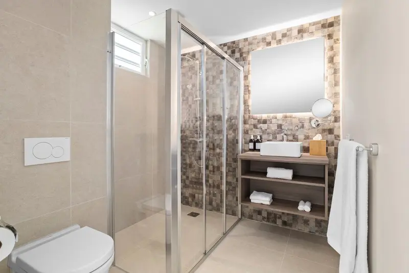 Une salle de bain moderne avec douche à l'italienne et vasque.