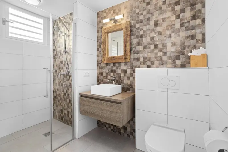 Une salle de bain moderne avec douche à l'italienne et lavabo sur meuble.
